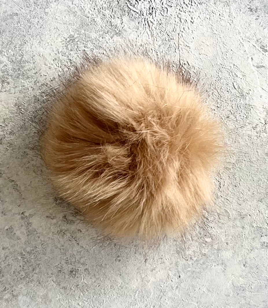 Navy cashmere plain knit beanie with an orange smiley embellishment & faux fur pom
